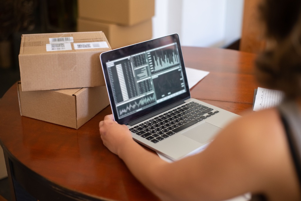 E-commerce merchant tracking inventory and competitor pricing analytics on laptop